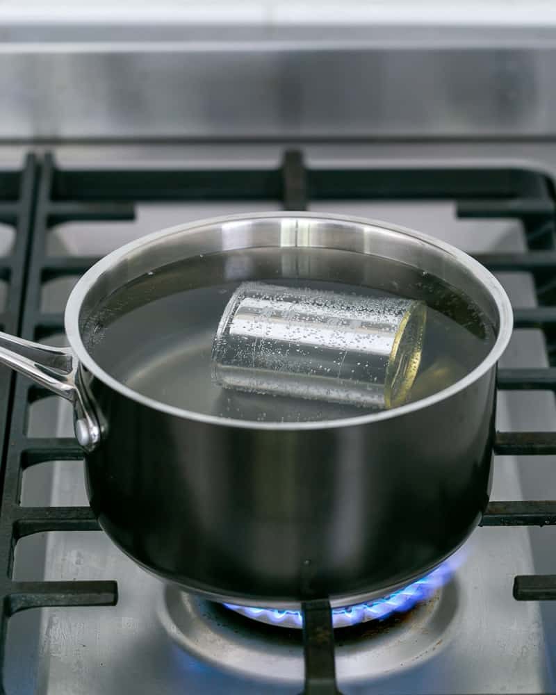 Immersing can of condensed milk in boiling water