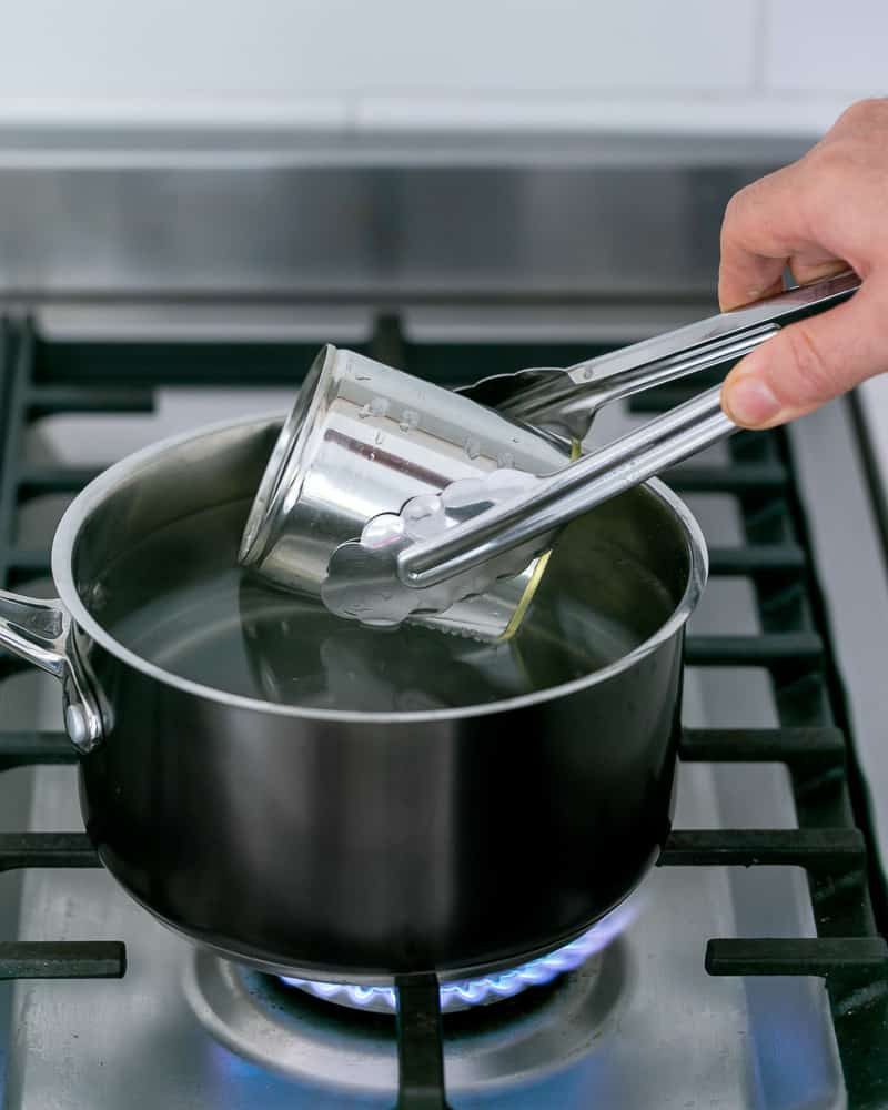 Immersing can of condensed milk in boiling water