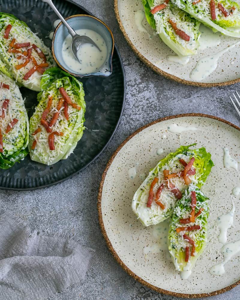 two halves of the Cos heart salad with buttermilk dressing and lardons plated up as an entree