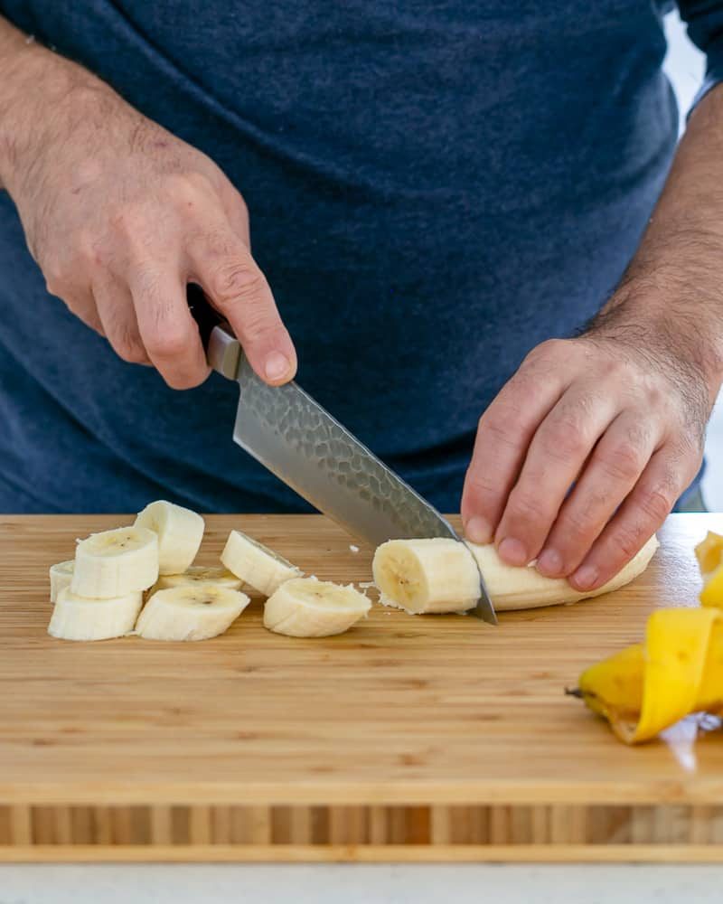 Person slicing banana to caramalize in butter for Dulce de Leche Verrine with Banana and whipped Cream