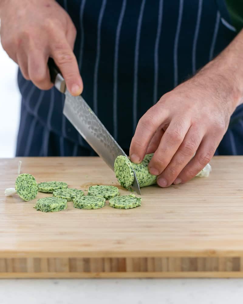 Slicing garlic butter in round discs for scallops baked in the shell