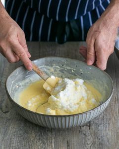 Folding in Whipped Egg Whites into Pancake Batter for Souffle-style pancakes with fresh ricotta and almonds