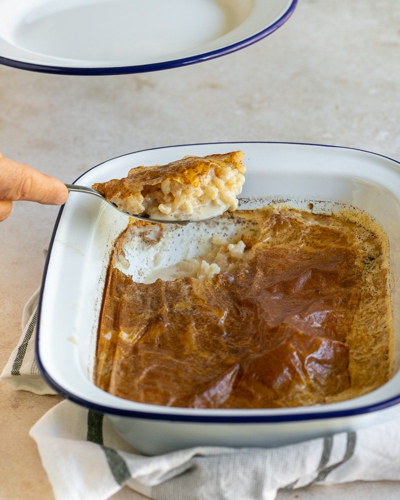 Serving the baked rice pudding with a spoon