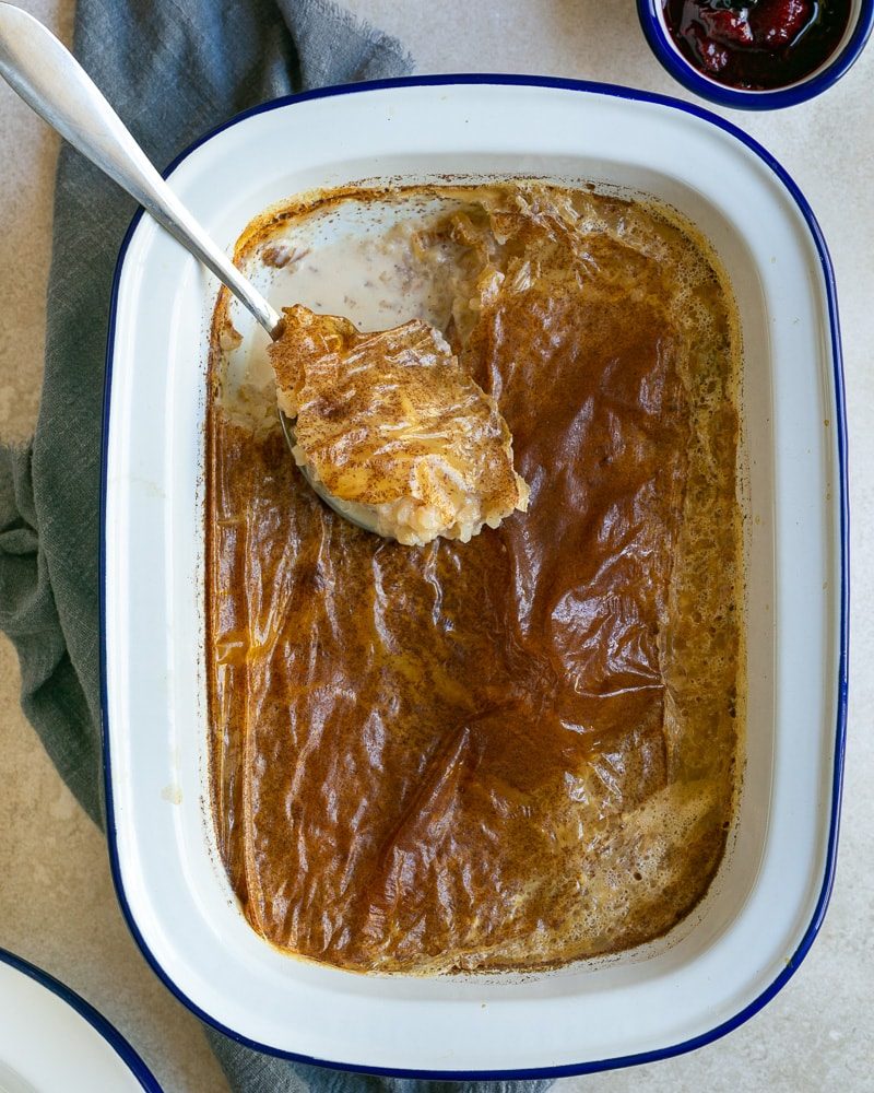 French Baked Rice Pudding with a spoon in the baking dish