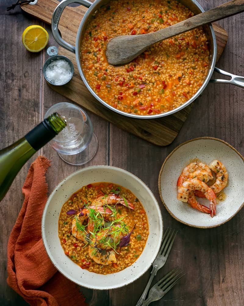 Garlic roasted prawns with fregola sarda served in a pan with prawns on the side