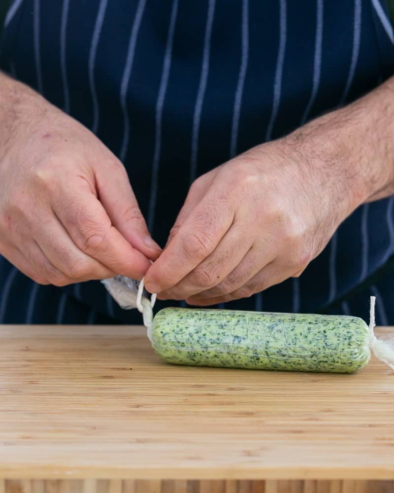 Tie ends of the garlic Herb butter log wrapped in a cling with a string