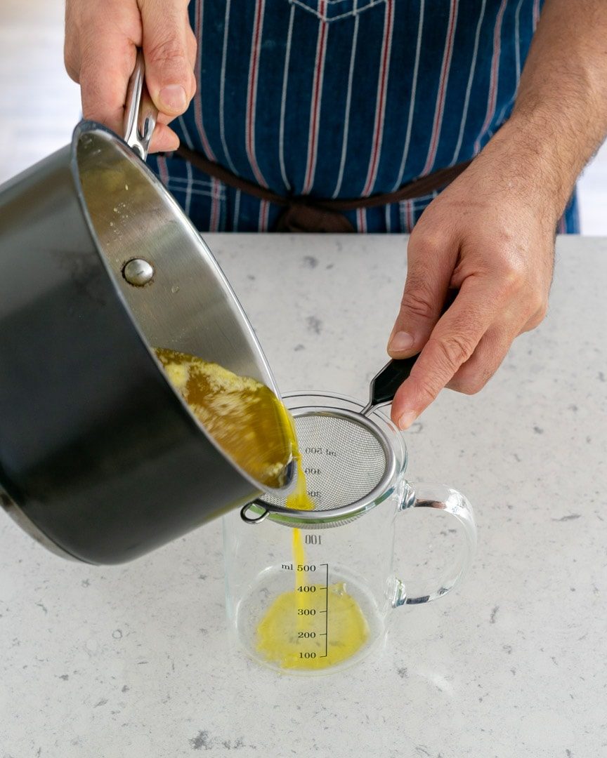 Straining clarified butter through a sieve