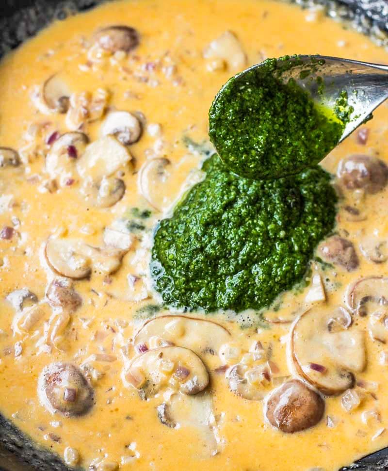 Pesto sauce added to rigatoni with brown mushrooms