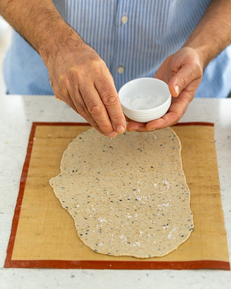 Sprinkling sea salt on rolled out lavosh dough