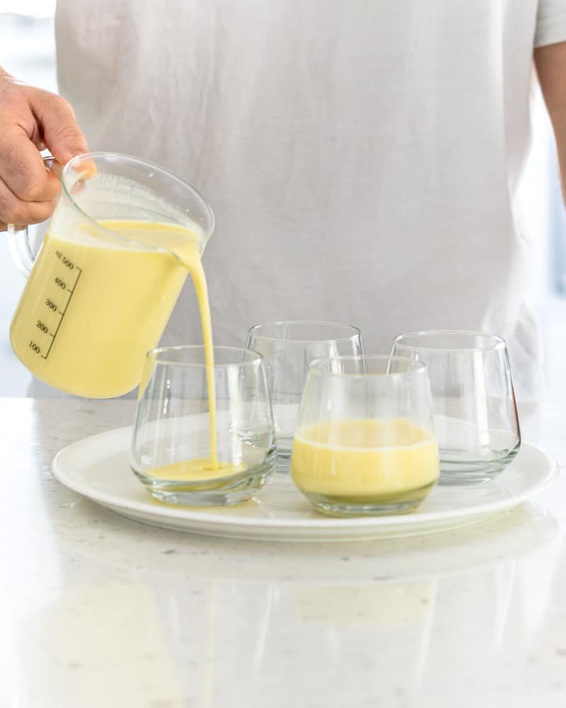 Person pouring the posset mixture into glasses