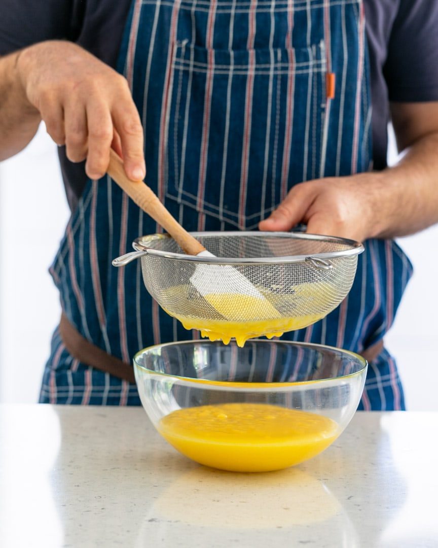 Straining the lemon curd through a sieve