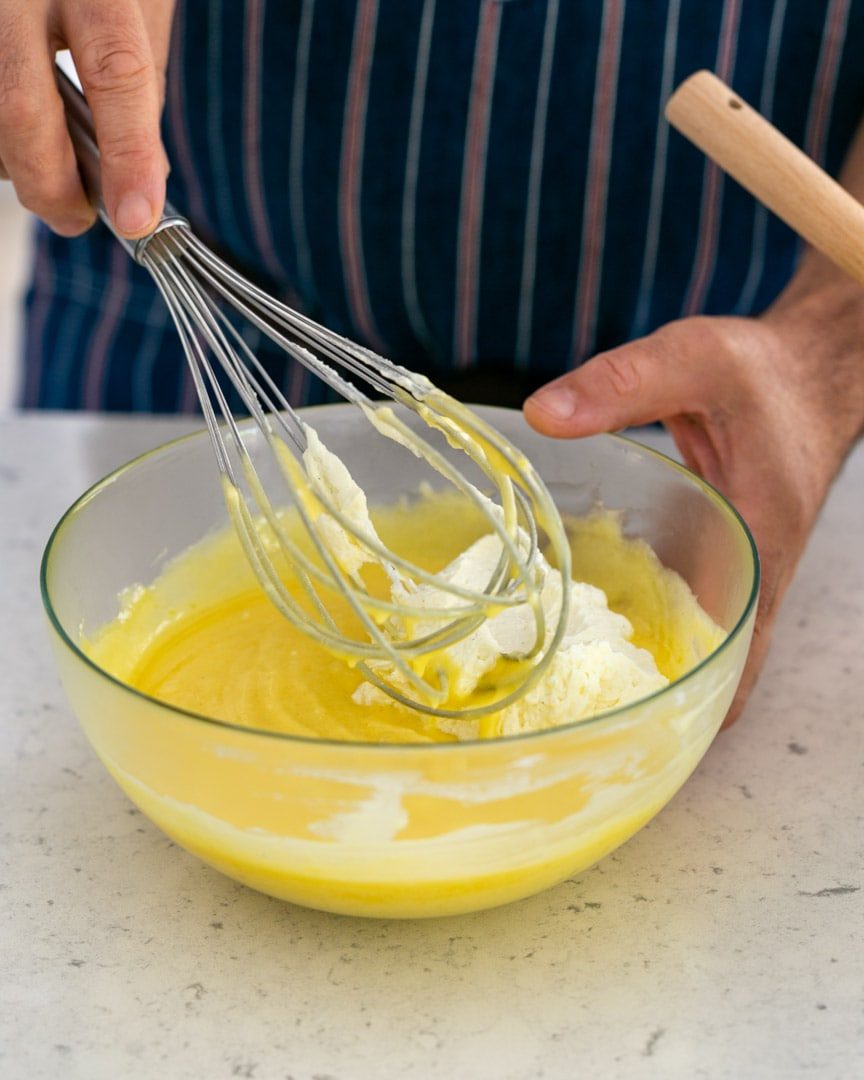 Folding in whipped cream into lemon curd with a whisk
