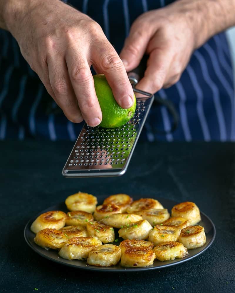 Grating lime zest on caramelized bananas for Dulce de Leche Verrine with Banana and whipped Cream