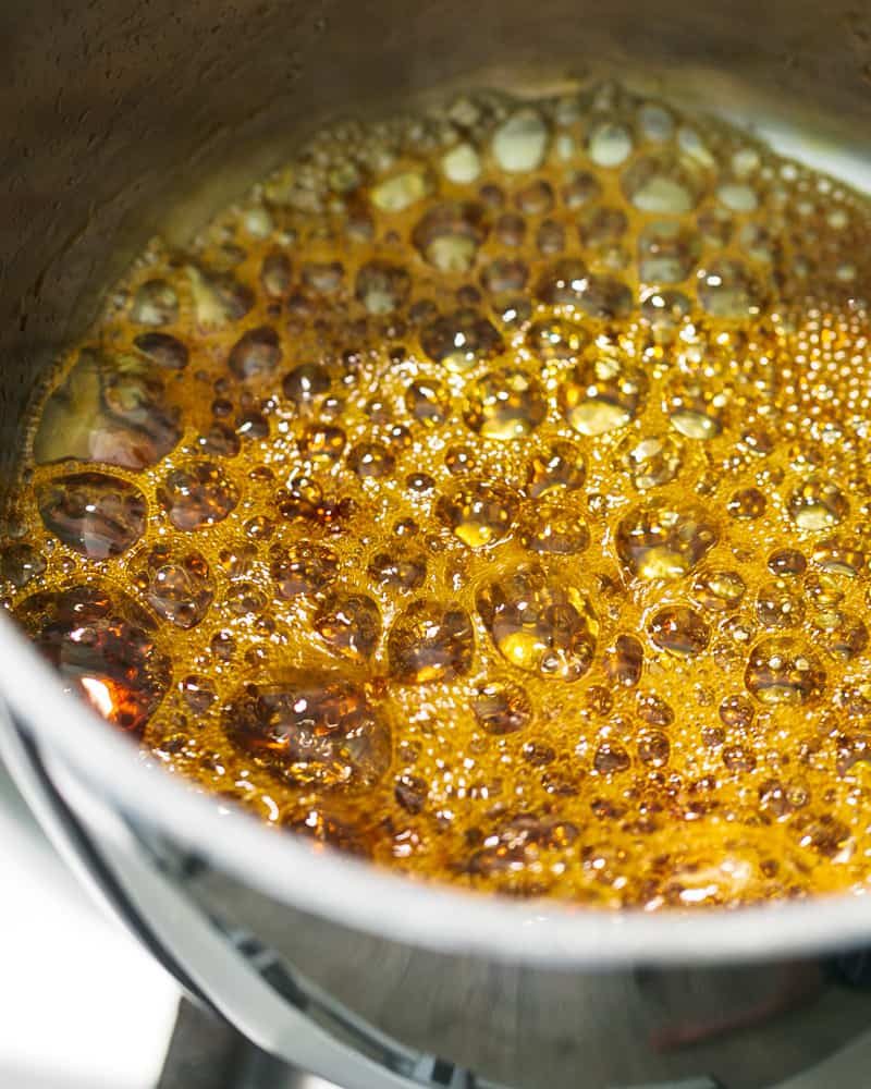 Sugar and water caramalising in a pot on the stove for sauce bigarade