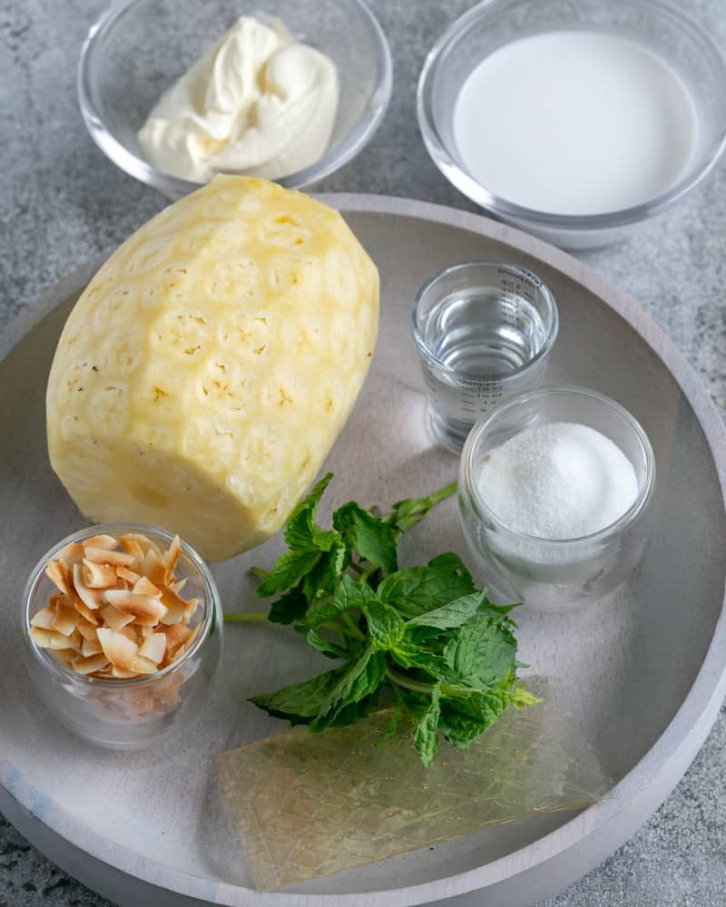 Ingredients Peeled whole pineapple, toasted coconut flakes, fresh mint leaves,gelatin,sugar,malibu rum,creme fraiche, sugar