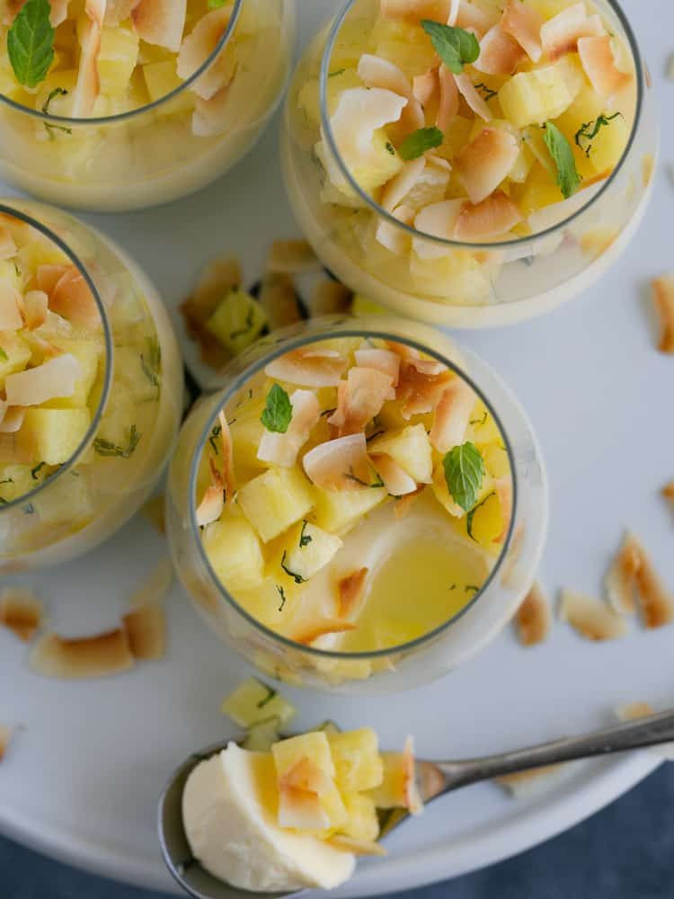 Overhead shot of prepared panna cotta in desert glasses with spoon full of panna cotta next to one of the glasses