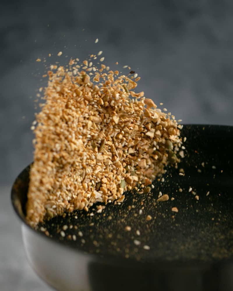 Dukkah ingredients tossed in a pan