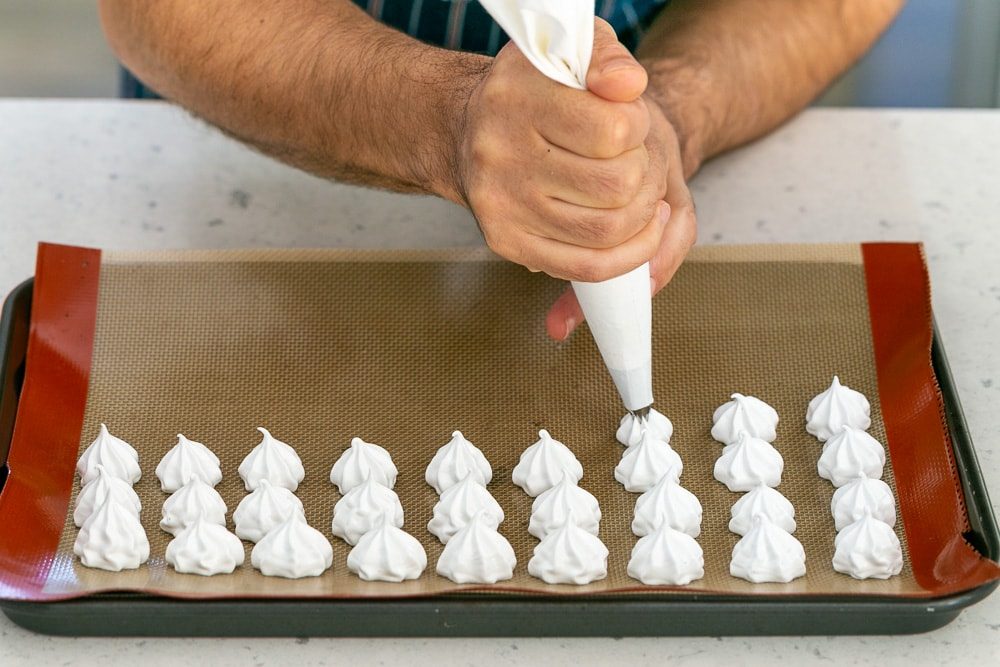 Piping meringue drops on a baking tray