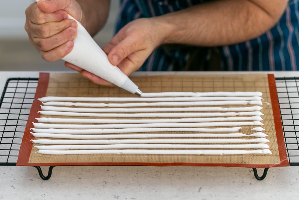 Piping meringue mix to make meringue sticks