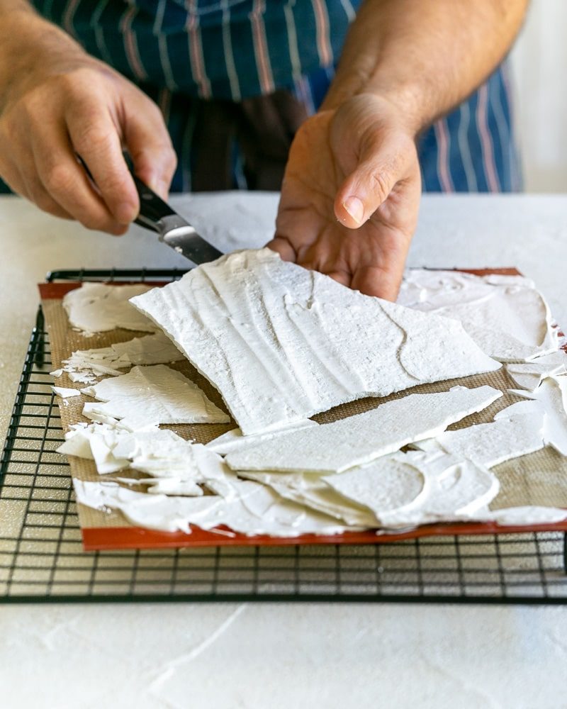 Taking Meringue shards off baking mat with a small knife