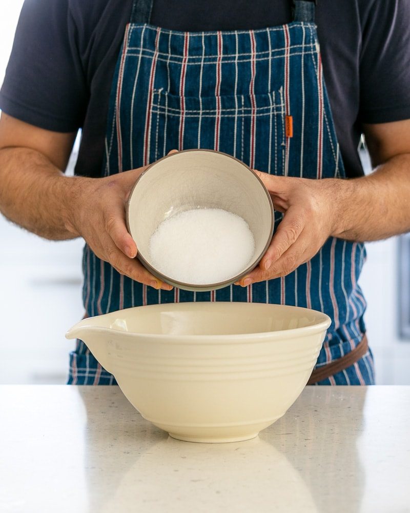 Sugar added to egg whites in bowl 