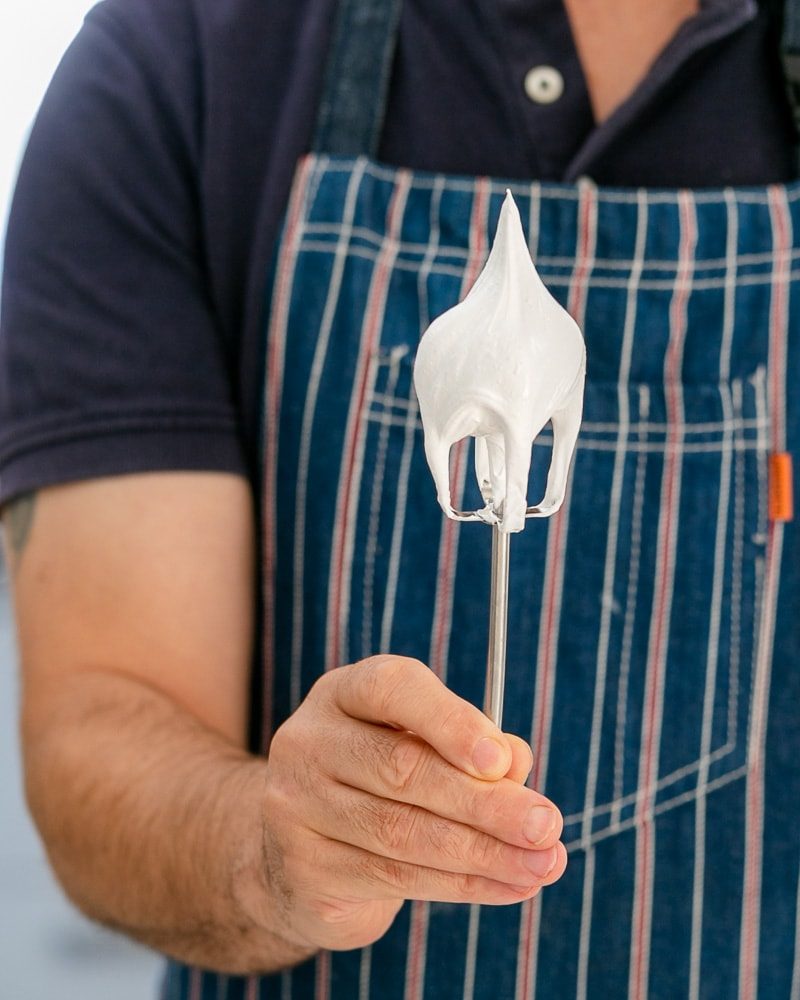 Showing consistency of the beaten egg white mix on a whisk