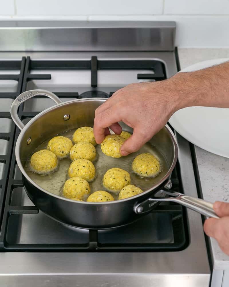 Deep frying paneer potato dumplings in oil