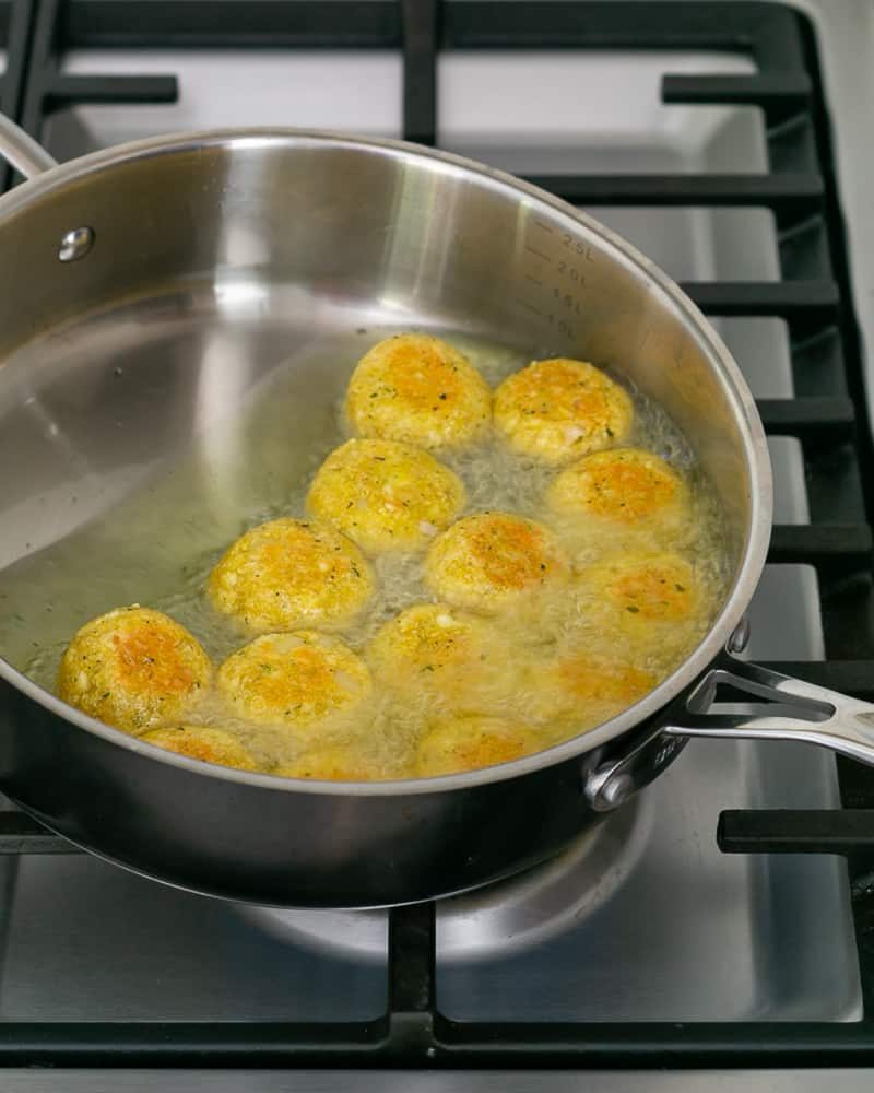Deep frying paneer potato dumplings in oil