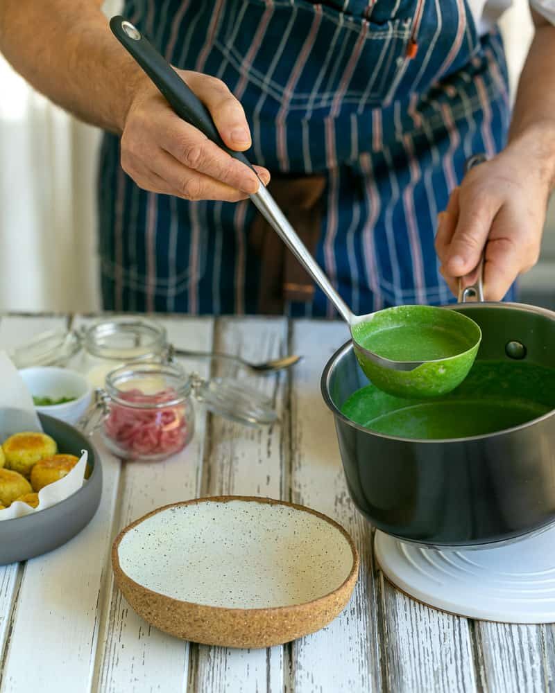 Ladle of the spinach sauce added to centre of the bowl