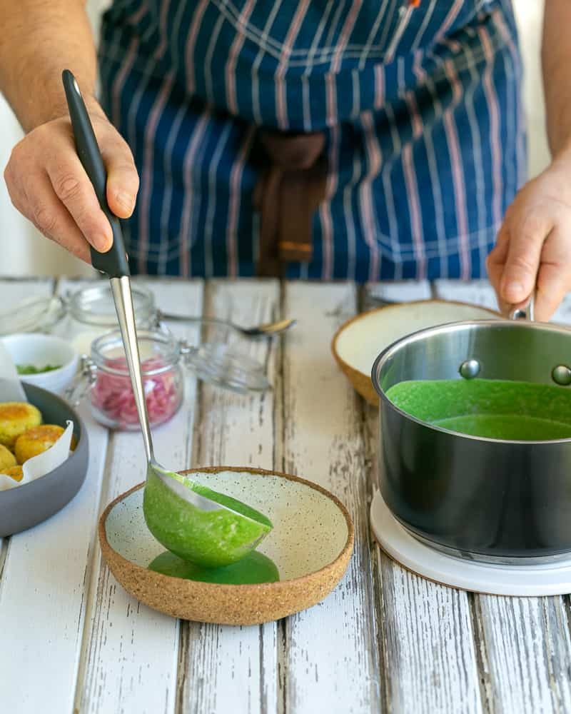 Ladle of the spinach sauce added to centre of the bowl