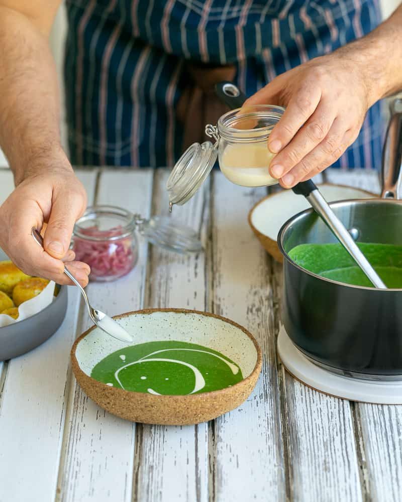 A swirl of fresh cream on the spinach soup