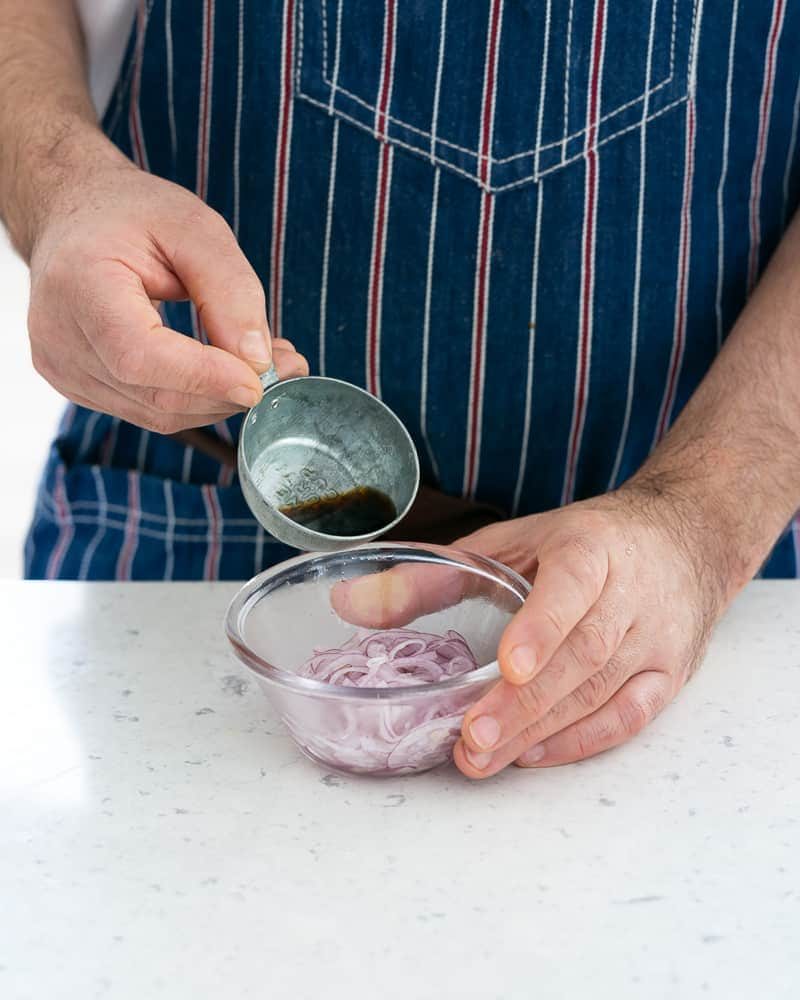 Red wine vinegar added to salted sliced onions