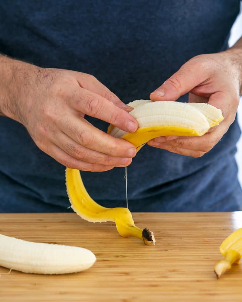 Person peeling banana to caramalize in butter for Dulce de Leche Verrine with Banana and whipped Cream