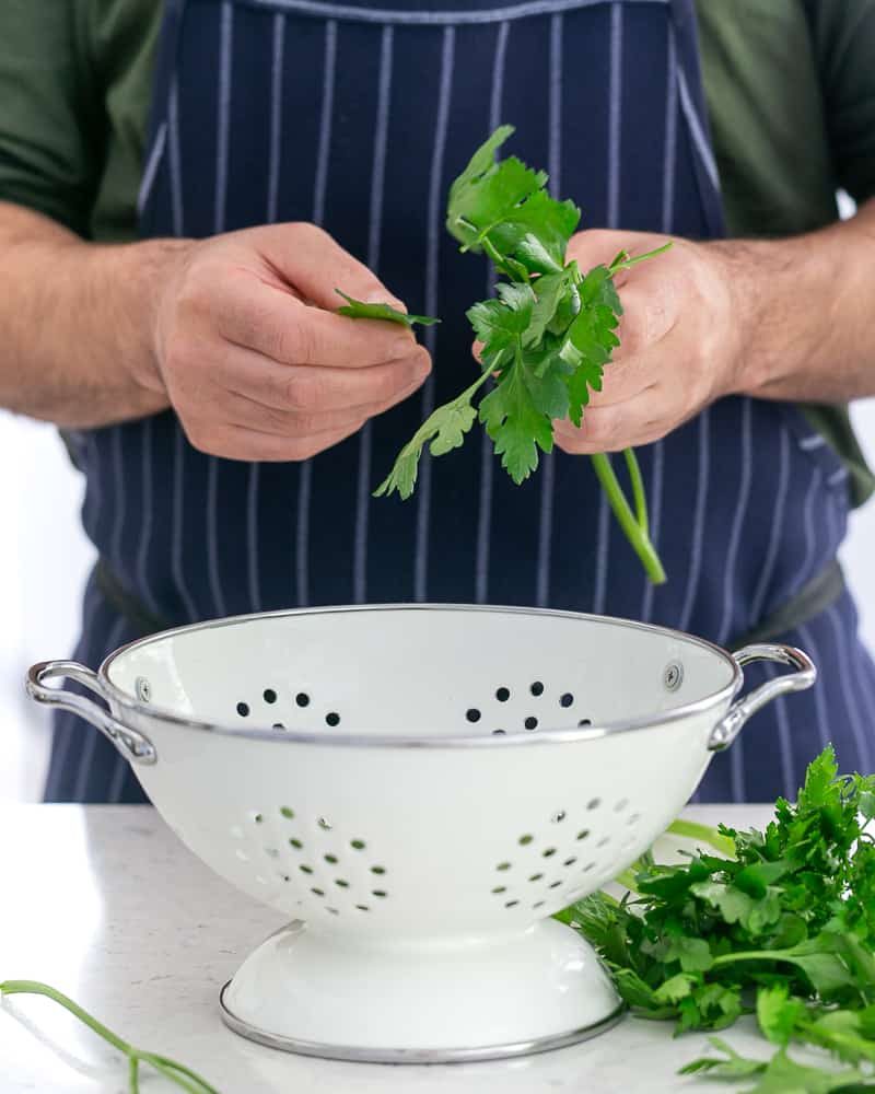 Person plucking parsley leaves to finely chop and add to garlic Herb butter