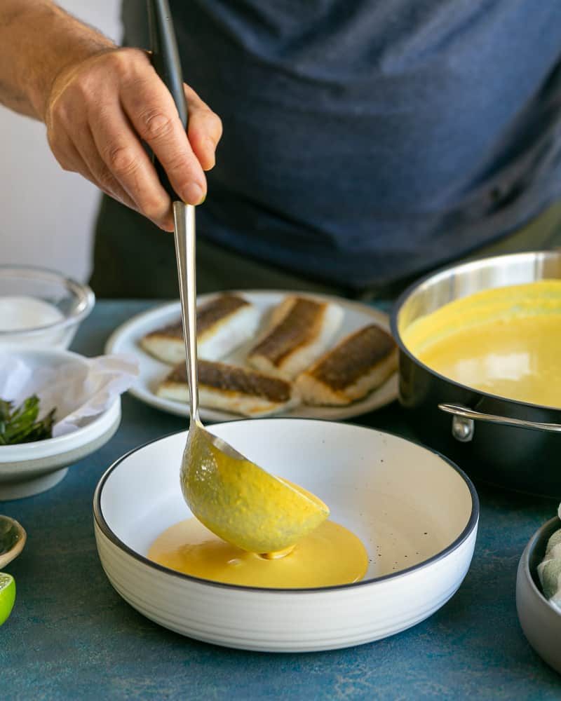 For plate up, ladel full of coconut curry sauce poured into bowl