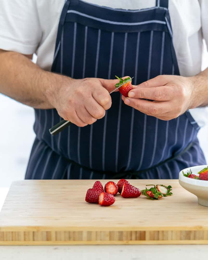 Cutting strawberries for Poached Rhubarb with Strawberries and Coconut Chantilly