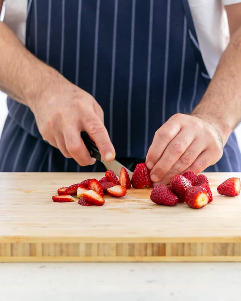 Slicing strawberries for Poached Rhubarb with Strawberries and Coconut Chantilly