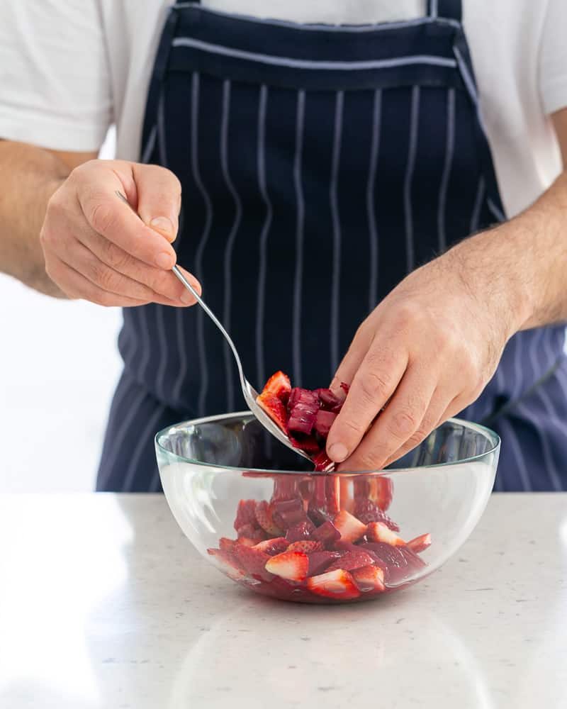 Mixing strawberries with the poached rhubarb