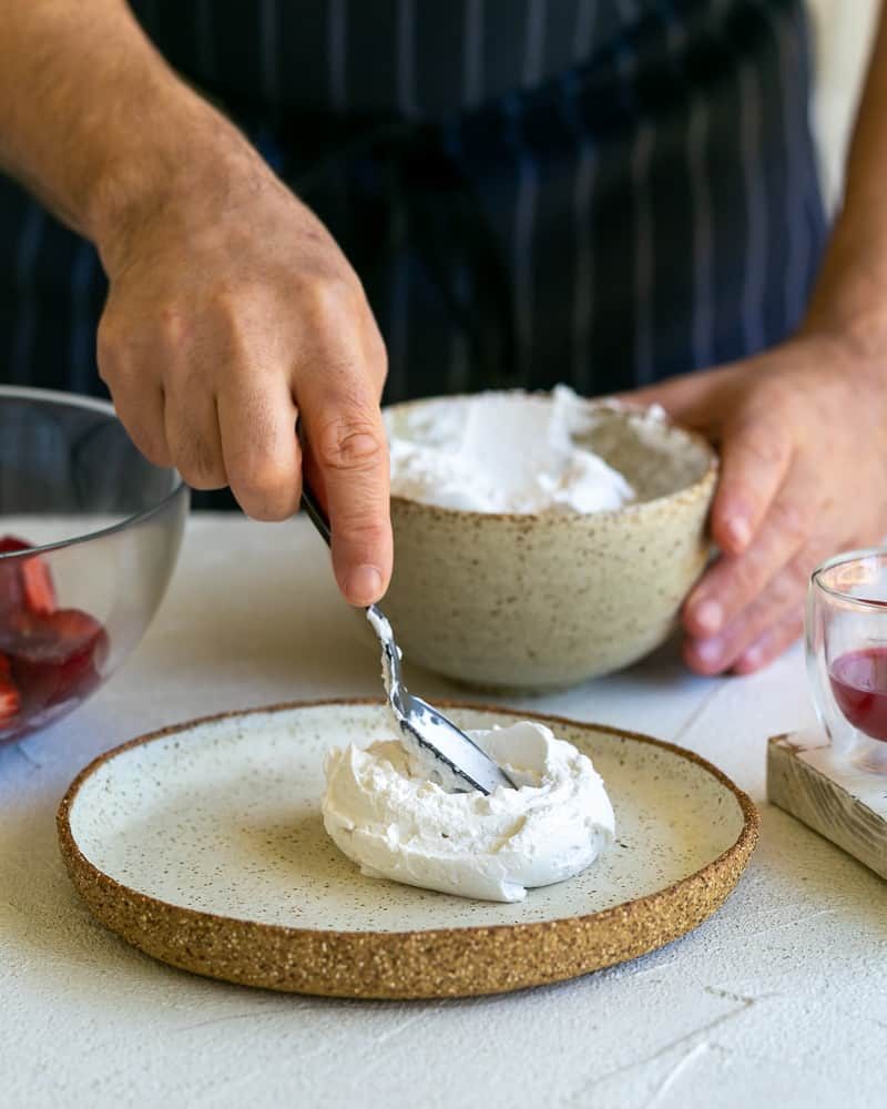 Spreading a spoonful of whipped coconut cream on a plate