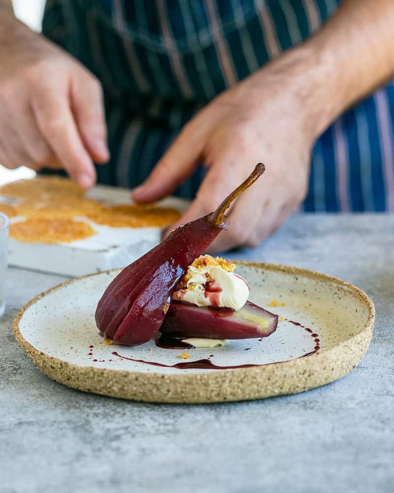 Spiced Poached pears with mascarpone plated in a ceramic plate