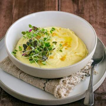 Classic Creamy Mashed Potato plated in a bowl with fresh herbs