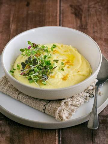 Classic Creamy Mashed Potato plated in a bowl with fresh herbs