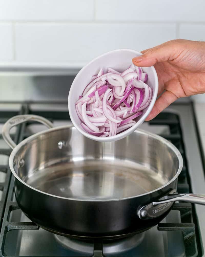 Sliced onions ready to be seared in a hot pan for making coconut curry sauce