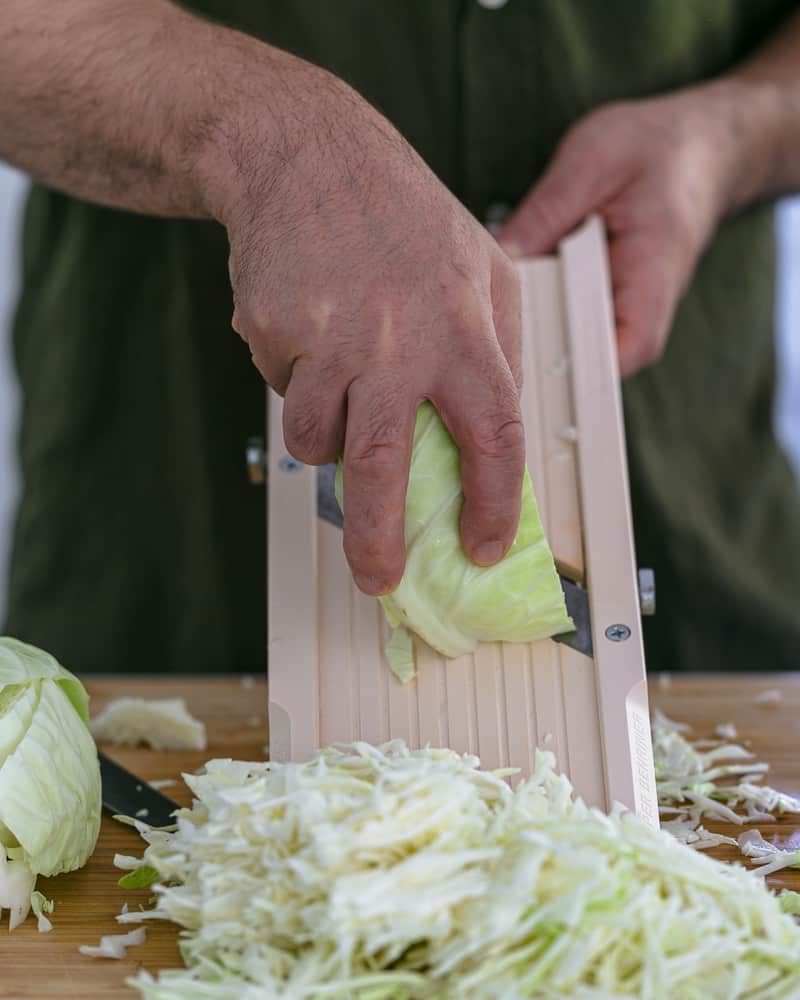 Shredding cabbage on a mandoline slicer