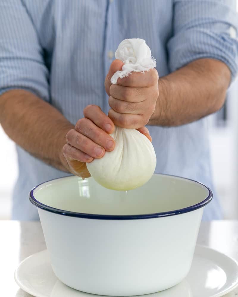 Wring the muslin cloth with the cheese to drain as much whey as possible to make paneer