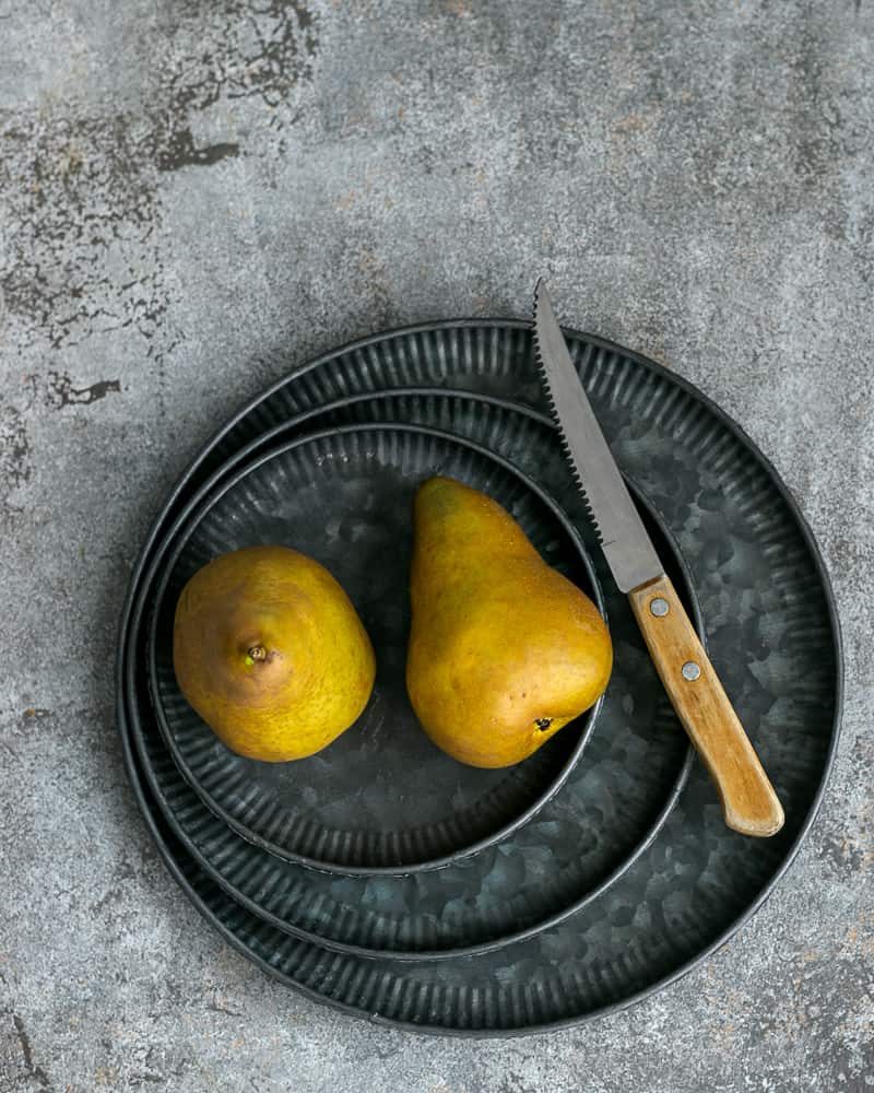 Two Pears on three galvanized plates and a knife