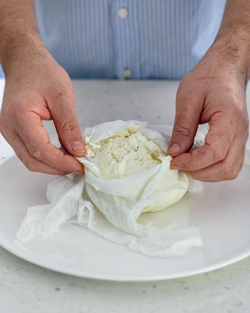 Showing how the cheese in the muslin cloth should look like after draining out the whey to make paneer