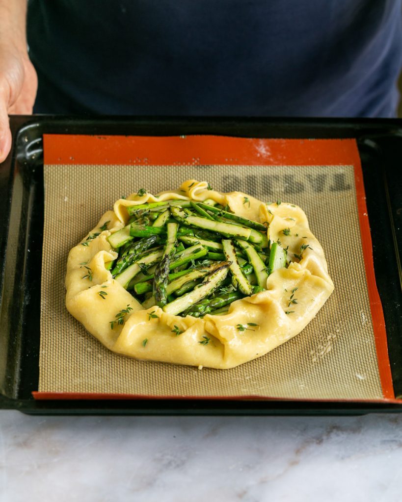 Asparagus and Parmesan crostata on a baking tray ready for the oven