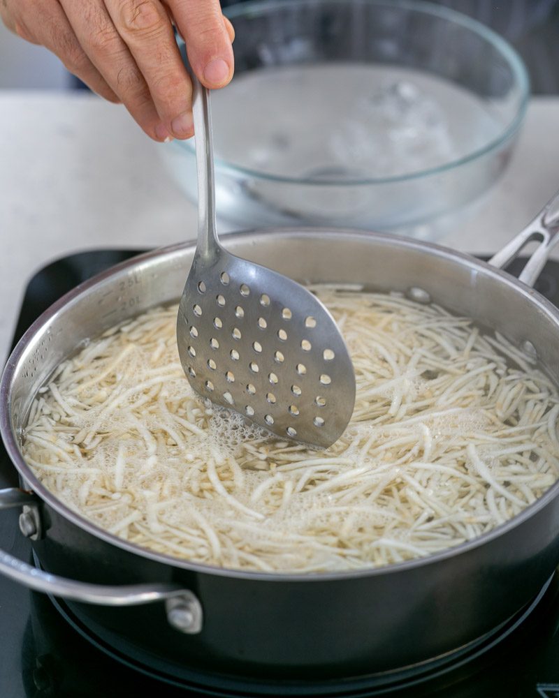 Blanching the shredded celeriac in boiling water