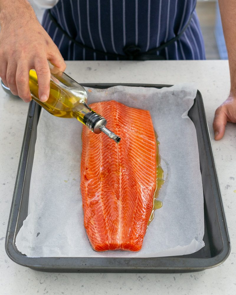 Adding olive oil on trout fillet